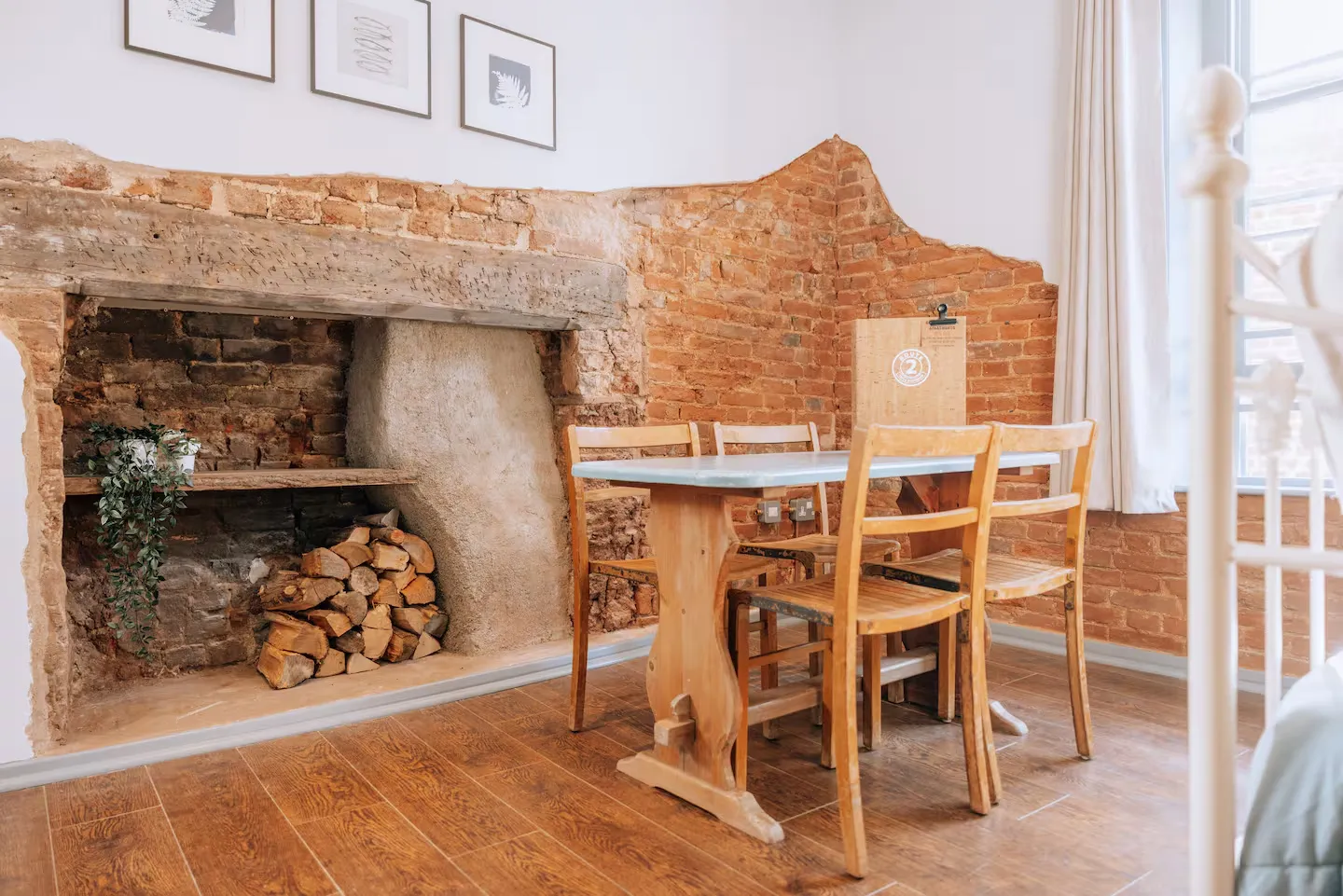 Dining area beside the original brick fireplace inside a Route 2 apartment